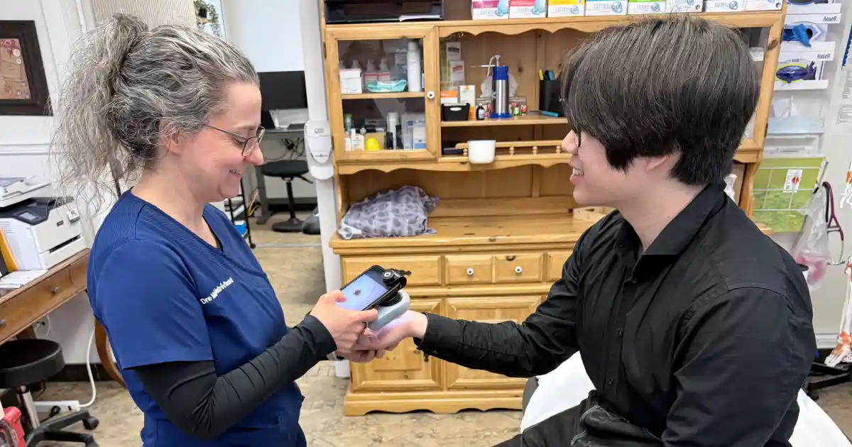 Médecin prenant une photo d’une lésion cutanée de son patient.